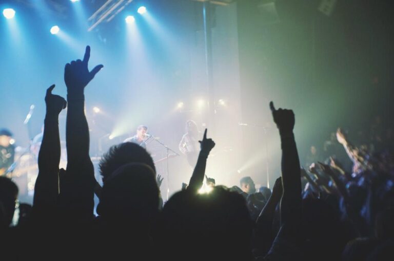 Público con las manos en alto en un concierto de hip hop